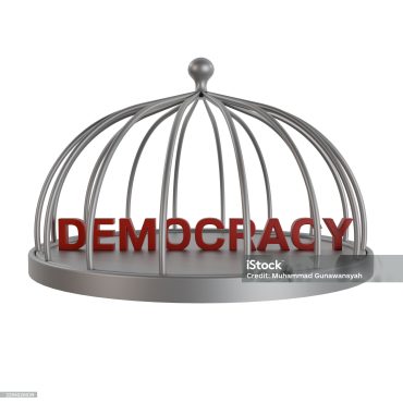 Red 3D word DEMOCRACY trapped in a silver cage. Symbolizing political restriction, censorship, and the suppression of freedom and human rights in a country